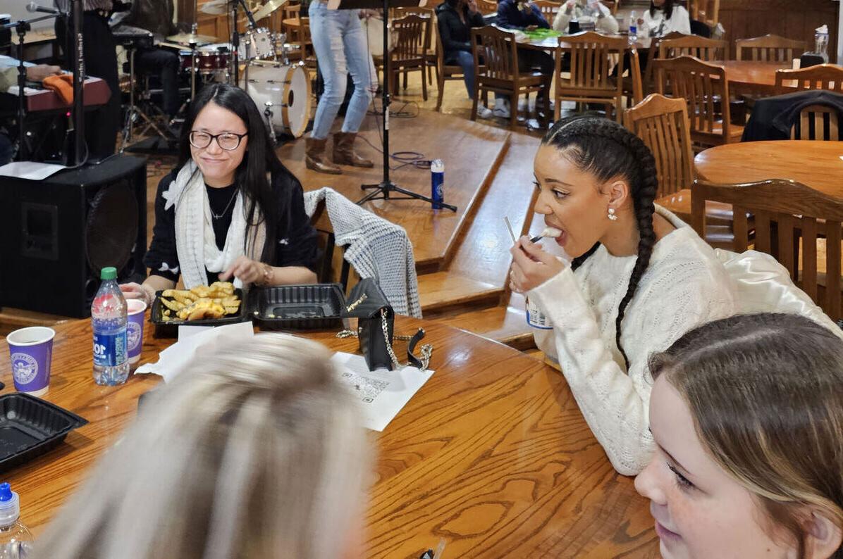 学生们在麦肯齐餐厅聊天吃饭，背景音乐是乐队演奏